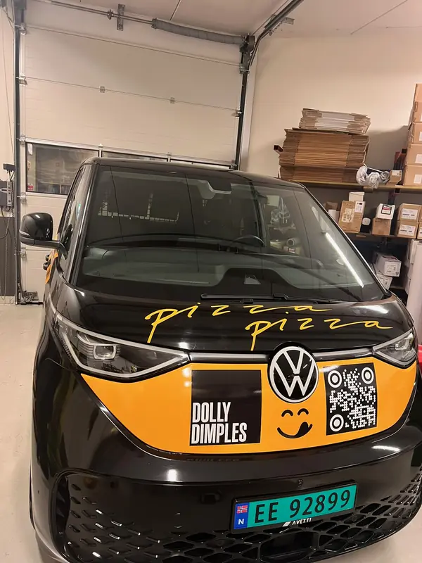 Varebil sett forfra med gul frontdekor, logo og QR-kode