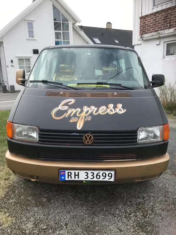 Eldre varebil foliert i sort og gull med håndskrevet logo på panseret