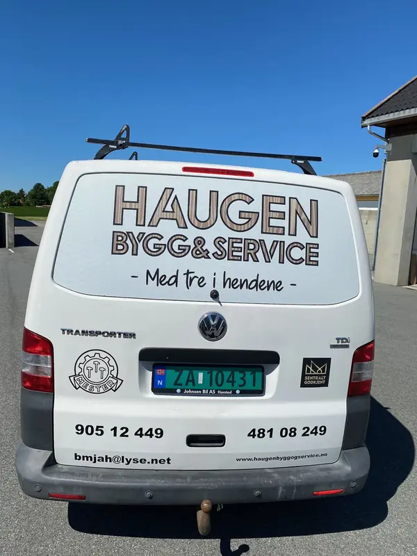 Hvit varebil med logo, telefonnummer og e-postadresse på bakluken