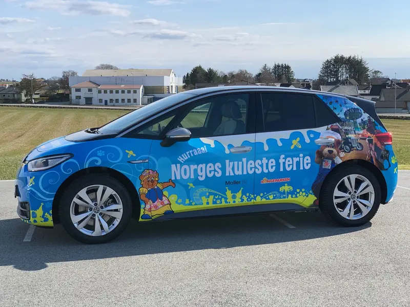 Elbil foliert over hele karosseriet med blå illustrasjoner og tekst