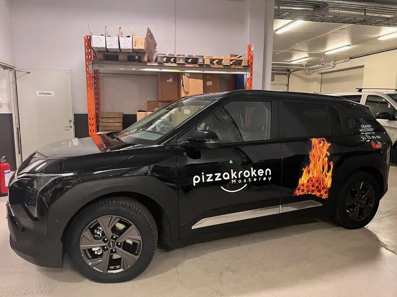 Sort SUV med logo på døren og flammedekor over bakskjermen