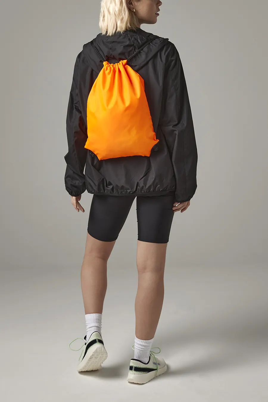Oransje gymbag med snøring, båret på ryggen