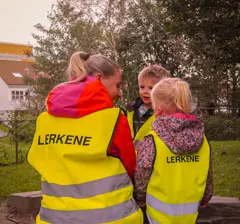 Barnehagegruppe i gule refleksvester med navn
