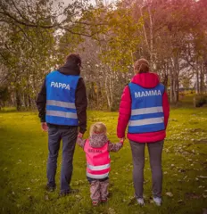 Familie i refleksvester med navn på ryggen