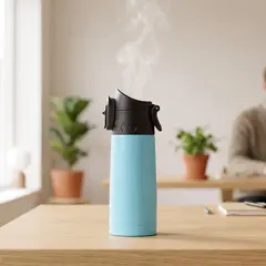 Termokopp på pulten i et lyst kontorlandskap